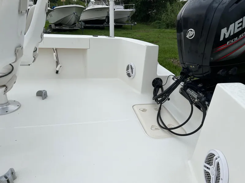 Slide: The Image of 2015 Mako 184 CC boat deck with Mercury outboard motor, parked on grass. - 3