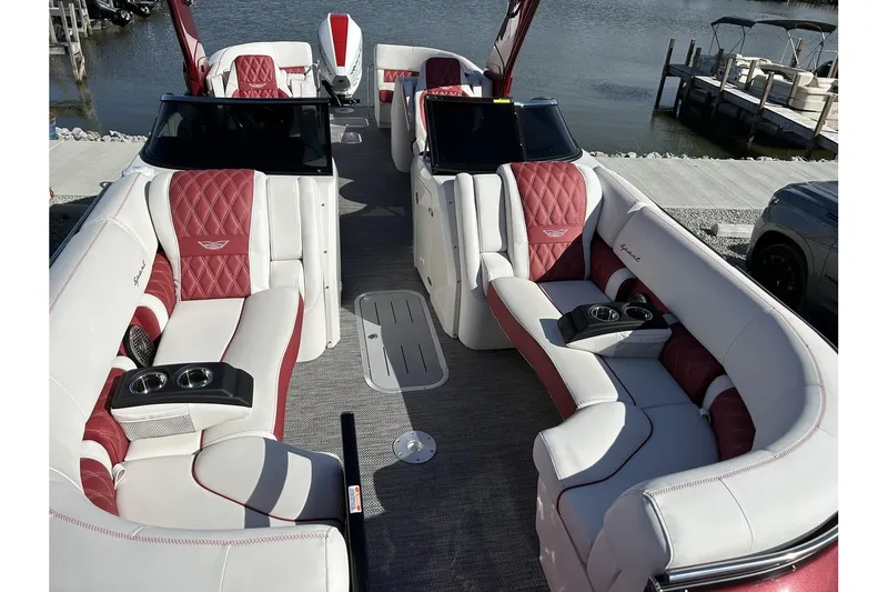 Slide: The Image of 2023 Bennington QX Sport 25 pontoon boat with luxurious red and white seating. - 8