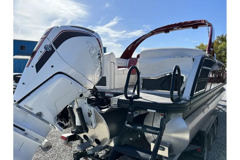 Slide: The Image of 2023 Bennington QX Sport 25 pontoon boat with powerful outboard motor. - 9