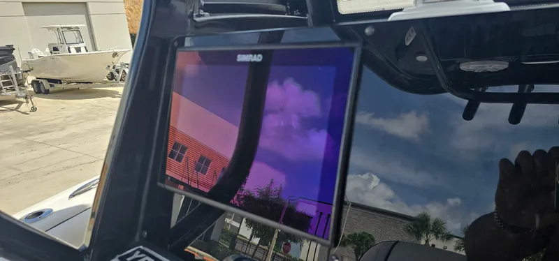 Slide: The Image of 2023 Tidewater 232 LXF boat with Simrad display, reflecting sky and buildings. - 19