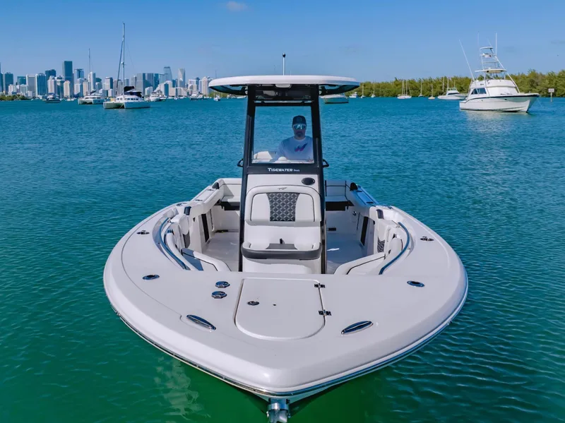 Slide: The Image of 2023 Tidewater LXF boat on clear blue water with city skyline in background. - 2