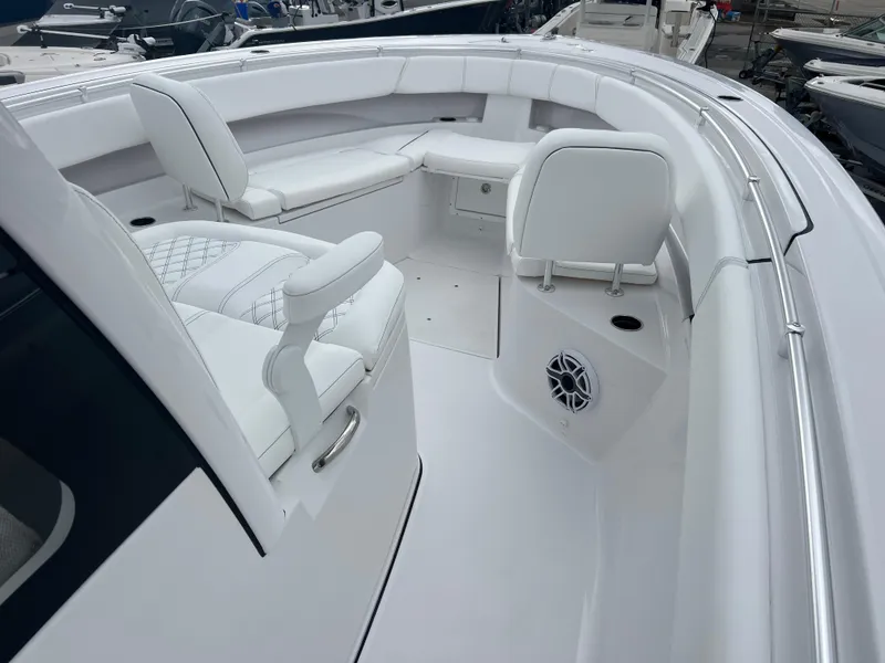 Slide: The Image of 2025 Sportsman Open 322 Center Console boat interior with white seating and speaker. - 14