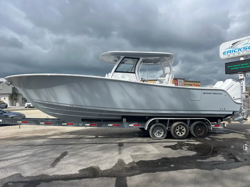 Slide: The Image of 2025 Sportsman Open 322 Center Console boat on a trailer under cloudy skies. - 2