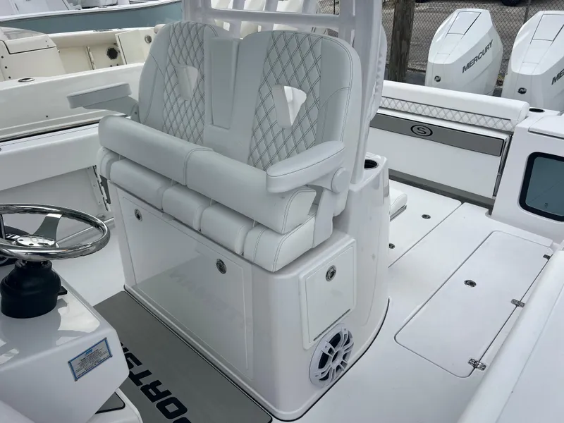 Slide: The Image of 2024 Sportsman Open 322 Center Console boat interior with white cushioned seating and steering wheel. - 21