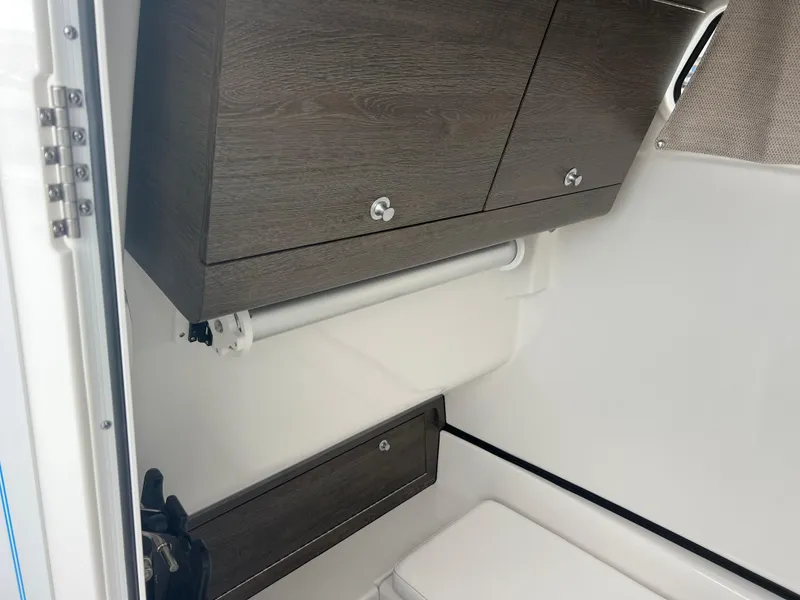 Slide: The Image of 2025 Sportsman Open 322 Center Console interior with wood cabinets and white walls. - 25