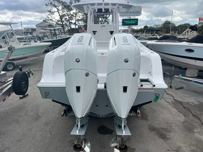 Slide: The Image of 2025 Sportsman Open 322 Center Console boat with dual engines, docked at a marina. - 6