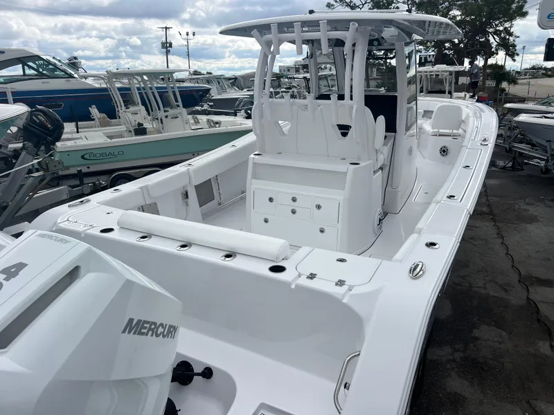 Slide: The Image of 2025 Sportsman Open 322 Center Console boat with Mercury engine, docked at marina. - 7
