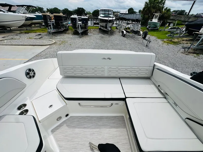 Slide: The Image of 2025 Sea Ray SPX 210 boat interior with white seating and storage compartments. - 10