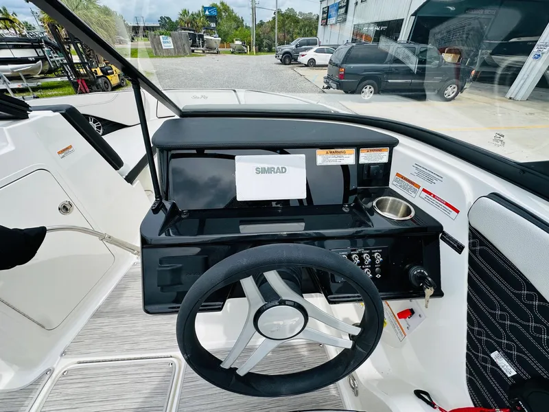 Slide: The Image of 2025 Sea Ray SPX 210 boat dashboard with steering wheel and Simrad display. - 13