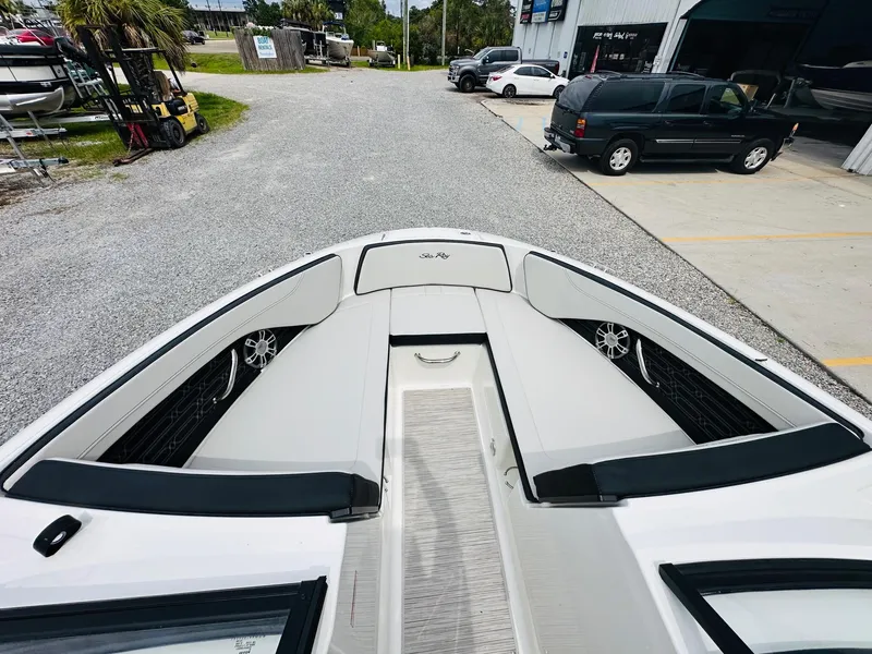 Slide: The Image of 2025 Sea Ray SPX 210 boat bow seating area with white cushions and black accents. - 16
