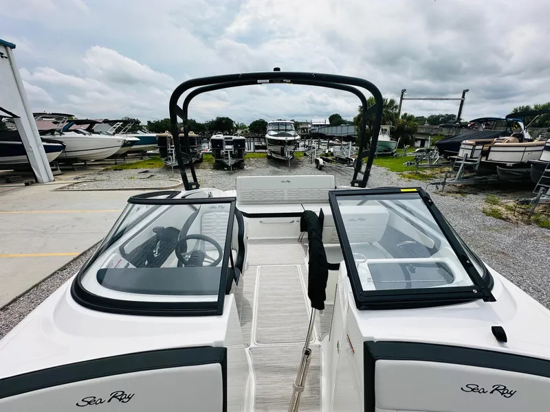 Slide: The Image of 2025 Sea Ray SPX 210 boat at a marina, showcasing open deck and seating. - 18
