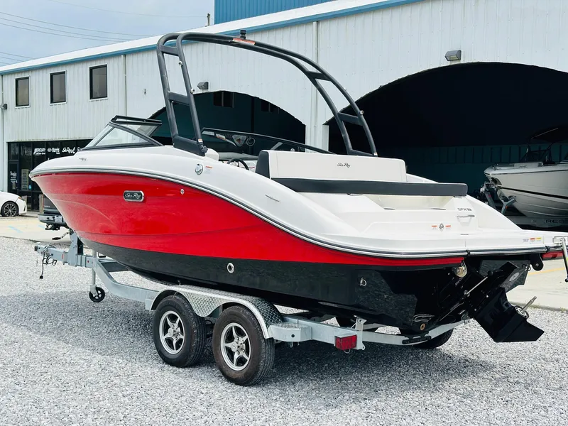 Slide: The Image of 2025 Sea Ray SPX 210 boat on trailer, red and black hull, parked outside. - 3