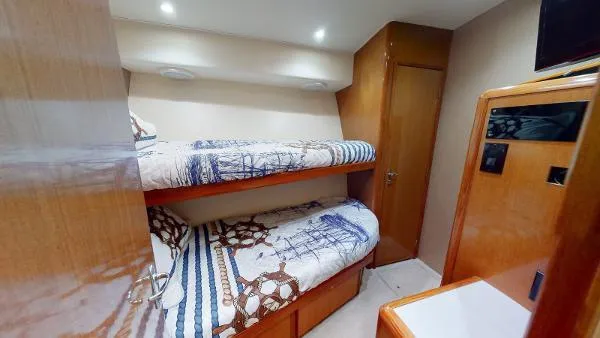 Slide: The Image of 1999 Viking 72 Sport Fish cabin with bunk beds and wooden interior. - 11