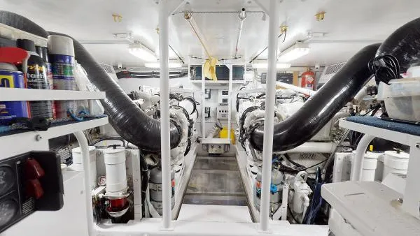 Slide: The Image of Engine room of a 1999 Viking 72 Sport Fish boat with twin engines and maintenance supplies. - 15