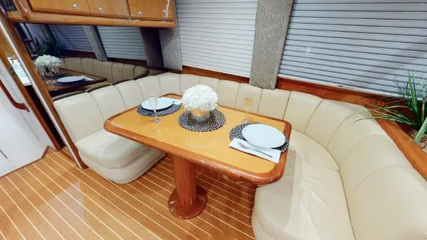 Slide: The Image of 1999 Viking 72 Sport Fish yacht interior dining area with elegant table setting and plush seating. - 28