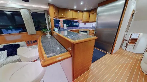 Slide: The Image of 1999 Viking 72 Sport Fish yacht interior with modern kitchen and seating area. - 29