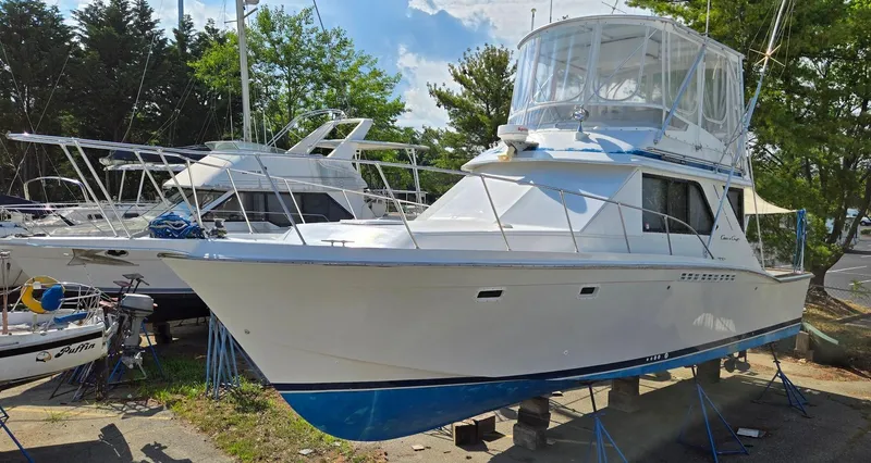 Slide: The Image of 1989 Chris-Craft 392 Commander yacht on dry dock, white hull with blue accents. - 1