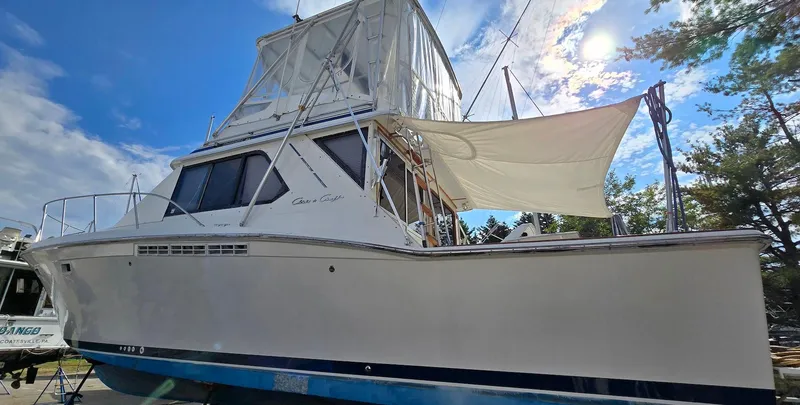 Slide: The Image of 1989 Chris-Craft 392 Commander yacht with white hull and blue accents docked under a sunny sky. - 4