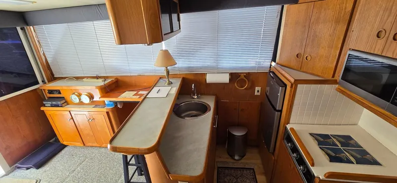 Slide: The Image of 1989 Chris-Craft 392 Commander yacht kitchen with wooden cabinetry and modern appliances. - 9