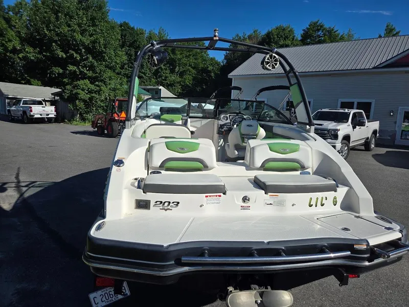 Slide: The Image of 2015 Chaparral 203V boat with green and white interior, parked outdoors. - 3