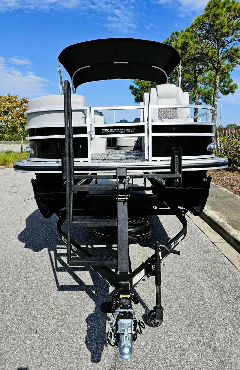 Slide: The Image of 2024 Ranger Reata 220FC pontoon boat on trailer, parked outdoors. - 5