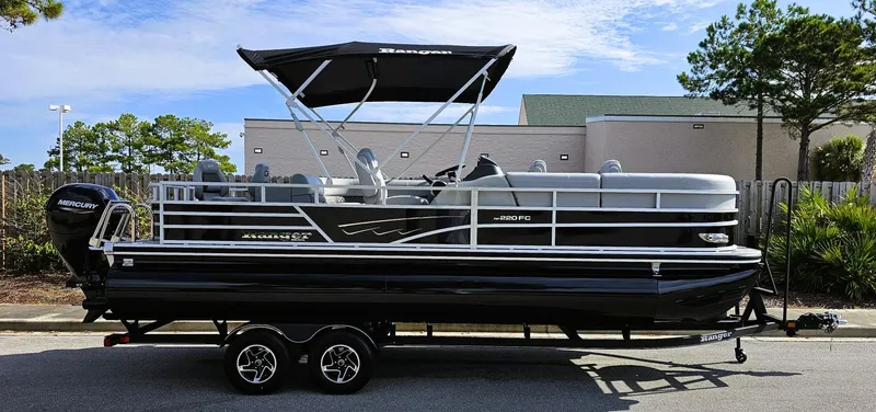 Slide: The Image of 2024 Ranger Reata 220FC pontoon boat on trailer, parked outdoors. - 9