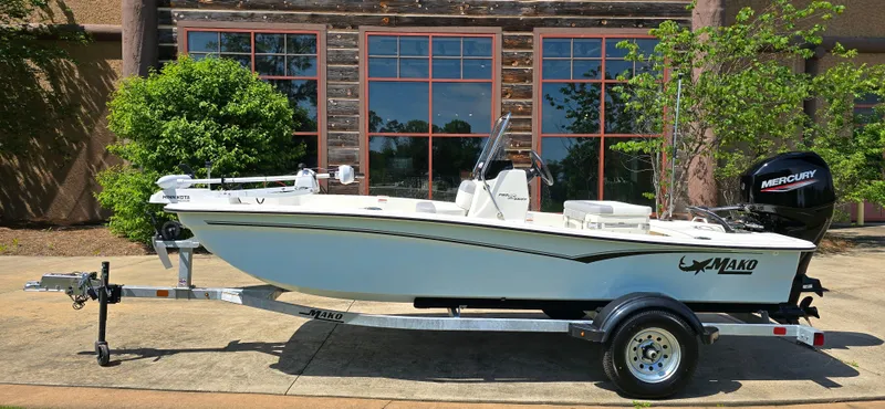 Slide: The Image of 2024 Mako Pro Skiff 15 CC boat on trailer, parked outdoors. - 2