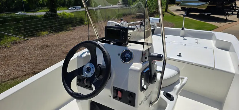 Slide: The Image of 2024 Mako Pro Skiff 15 CC boat console with steering wheel and controls. - 4