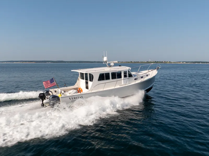 Slide: The Image of 2016 Wesmac 42 boat cruising on open water with American flag. - 1