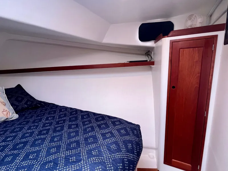 Slide: The Image of Cozy cabin interior of 2016 Wesmac 42 with blue bedding and wooden drawers. - 45