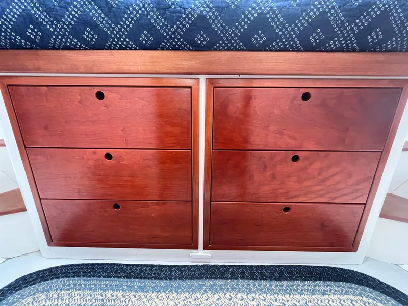 Slide: The Image of Cozy cabin interior of 2016 Wesmac 42 with blue bedding and wooden storage. - 46