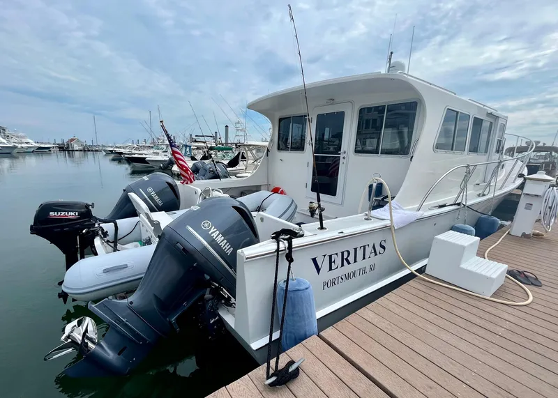 Slide: The Image of 2016 Wesmac 42 boat docked with twin outboard motors and American flag. - 6