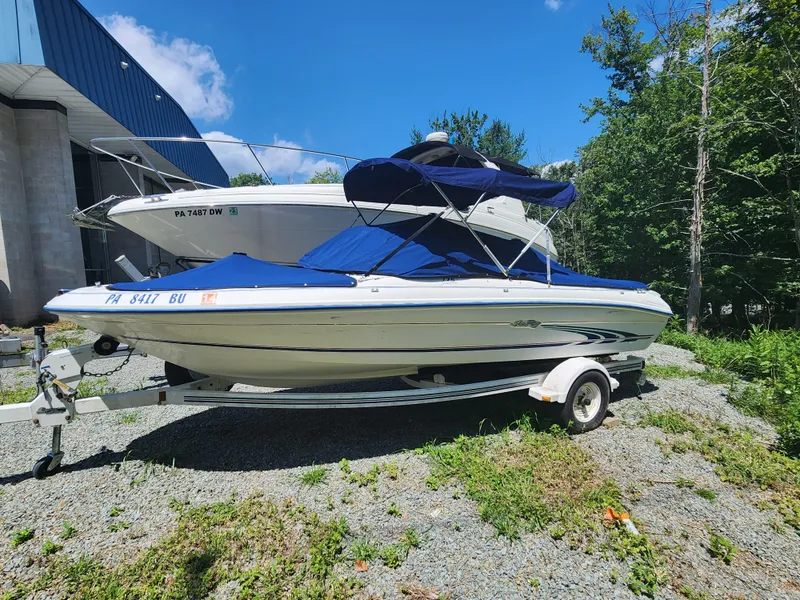 The Image of 1997 Sea Ray 175 Five Series boat on trailer, blue cover, parked outdoors. - 0