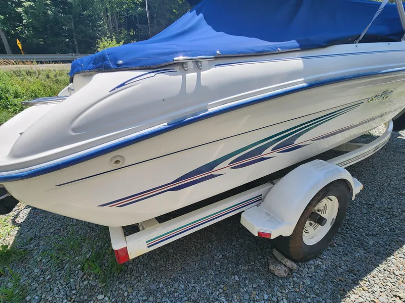 Slide: The Image of 1997 Sea Ray 175 Five Series boat on trailer with blue cover. - 2