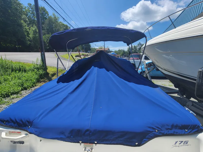 Slide: The Image of 1997 Sea Ray 175 Five Series boat with blue cover, parked outdoors. - 6