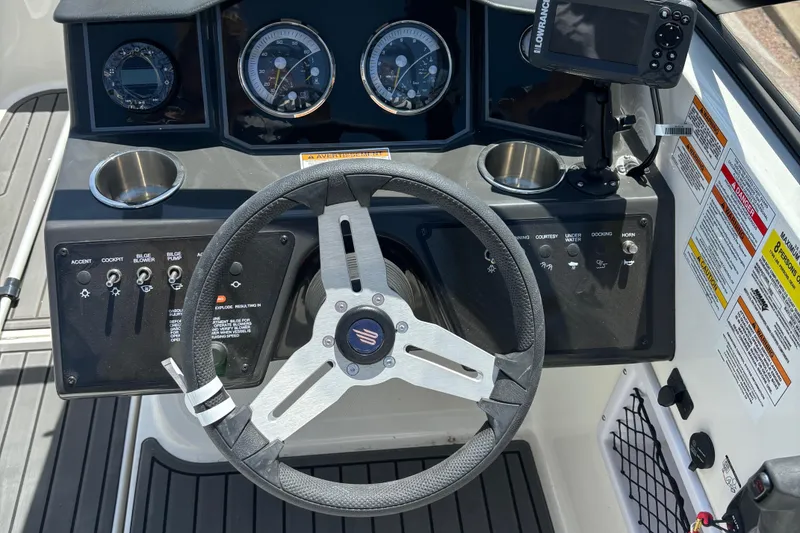 Slide: The Image of 2023 Bayliner VR5 boat dashboard with steering wheel, gauges, and controls. - 3