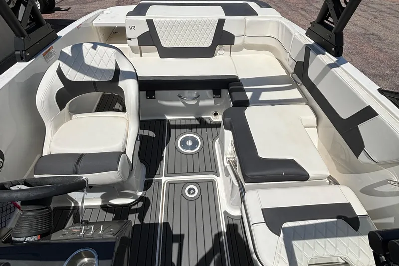Slide: The Image of 2023 Bayliner VR5 boat interior with white and black seating, steering wheel, and deck. - 5