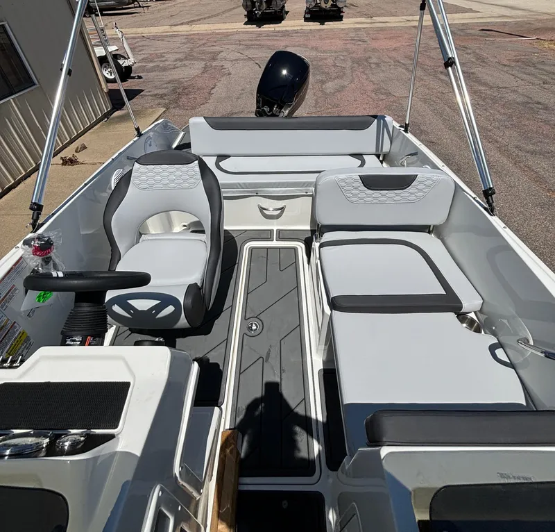 Slide: The Image of 2023 Bayliner E19 boat interior with seating and steering wheel. - 4