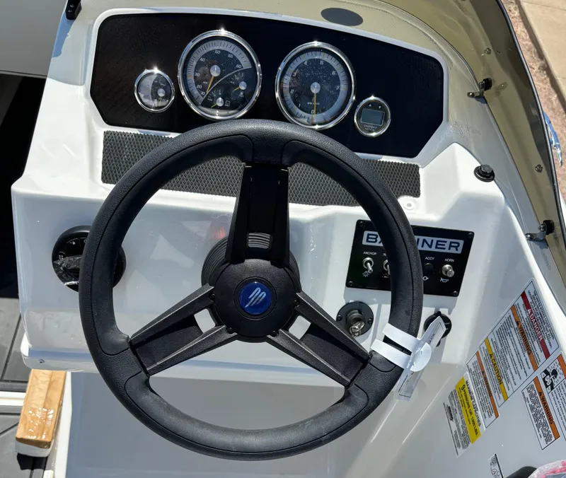 Slide: The Image of 2023 Bayliner E19 boat dashboard with steering wheel and gauges. - 5