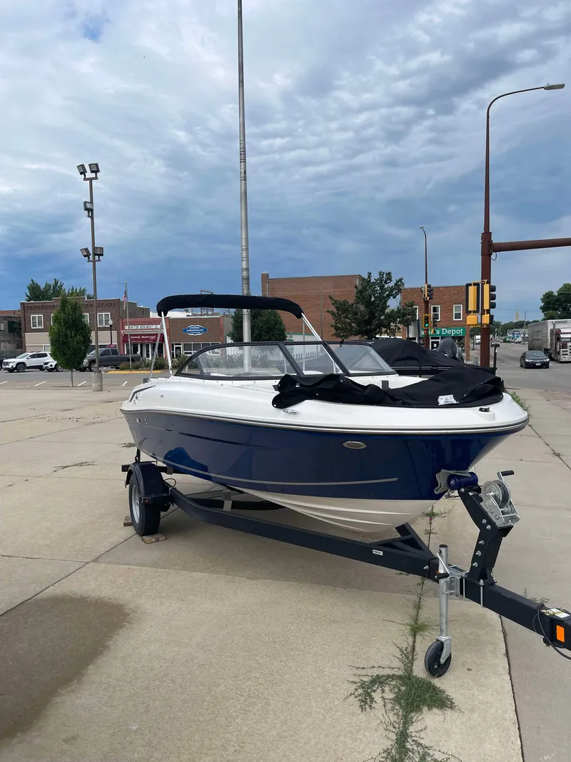 Slide: The Image of 2023 Bayliner VR4 boat on a trailer in an urban setting. - 0