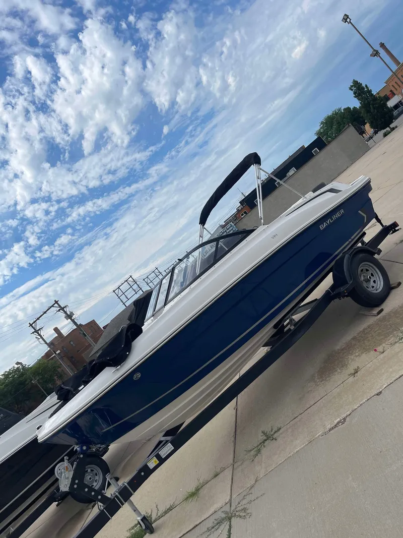 Slide: The Image of 2023 Bayliner VR4 boat on a trailer under a partly cloudy sky. - 5