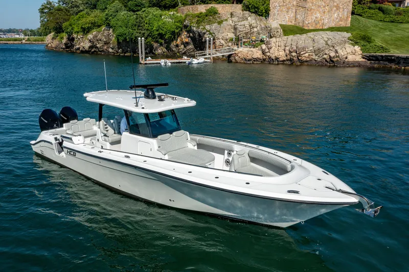 Slide: The Image of 2024 HCB 39 Speciale luxury boat on calm water near rocky shoreline. - 8