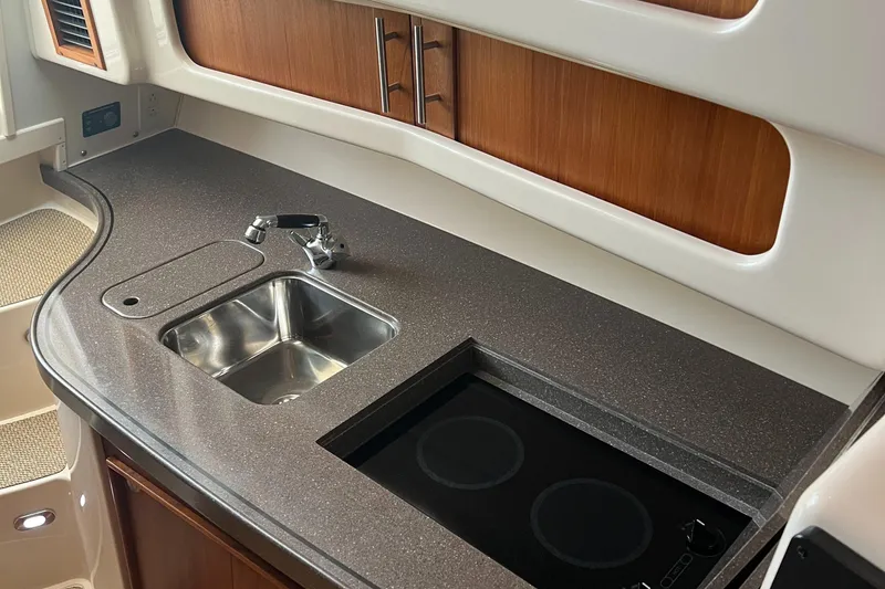 Slide: The Image of 2008 Grady-White Express 360 boat kitchen with sink, stove, and wooden cabinets. - 5