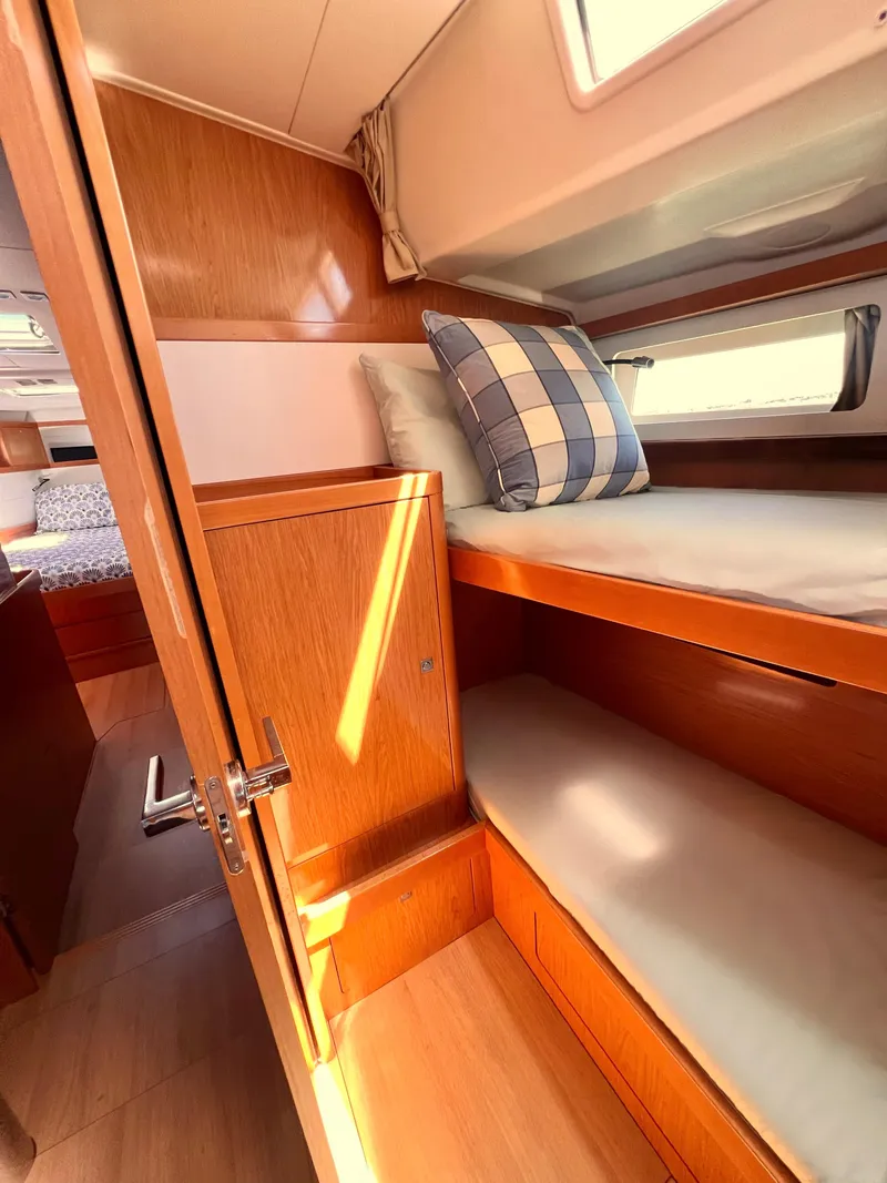 Slide: The Image of 2012 Beneteau Sense 50 interior cabin with bunk beds and wooden finish. - 12