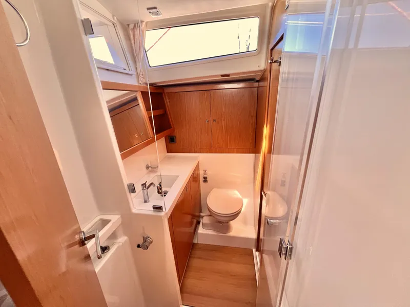 Slide: The Image of 2012 Beneteau Sense 50 yacht bathroom with modern fixtures and wooden cabinetry. - 13