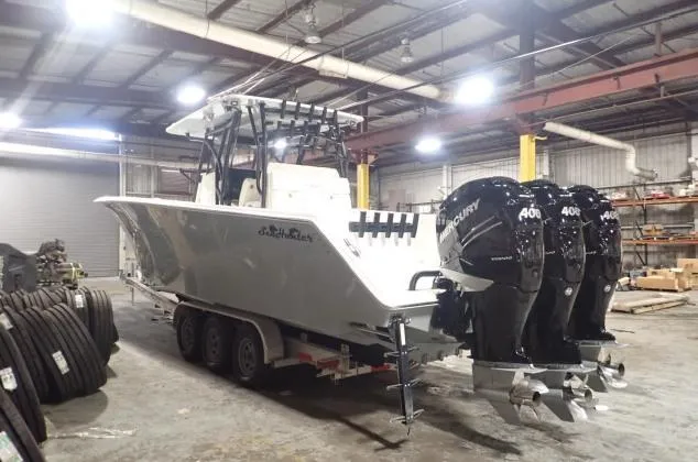 Slide: The Image of 2022 SeaHunter 35 Tournament boat with triple Mercury 400 engines in a warehouse. - 2