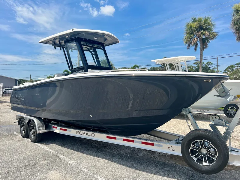 Slide: The Image of 2025 Robalo R250 boat on trailer under blue sky. - 1