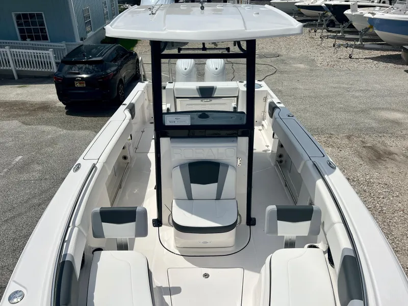 Slide: The Image of 2025 Robalo R250 boat interior with seating and console, parked in a marina. - 26