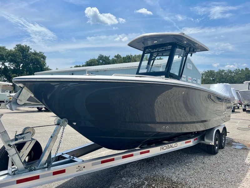 Slide: The Image of 2025 Robalo R250 boat on trailer under blue sky. - 3