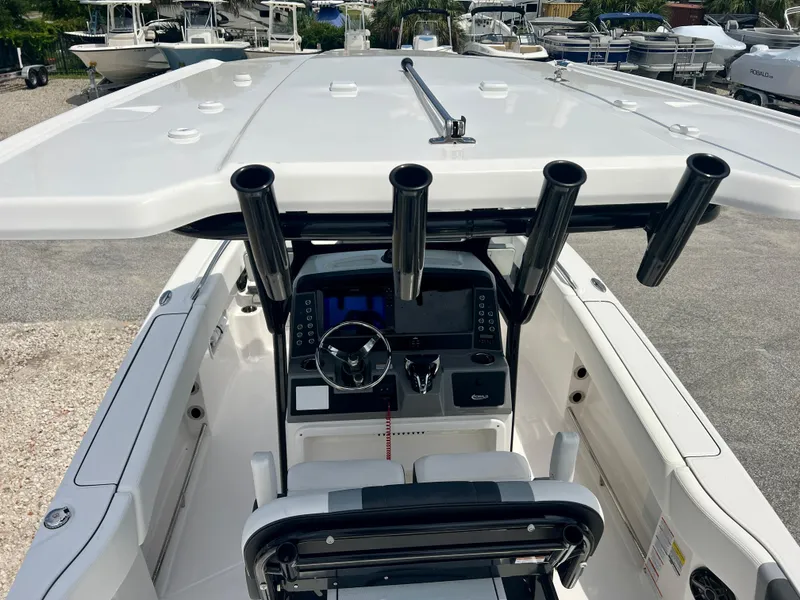Slide: The Image of 2025 Robalo R250 boat cockpit with steering wheel, control panel, and rod holders. - 30